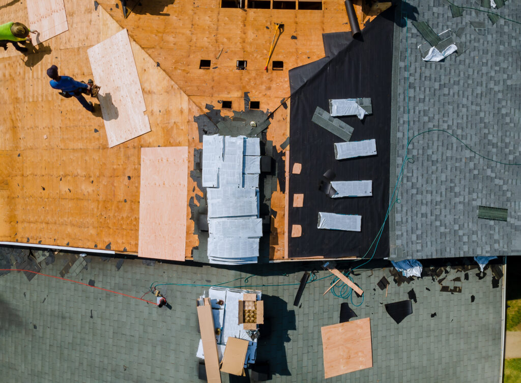 A roofer in Silver Spring, MD, nailing new shingles on a reroof project.